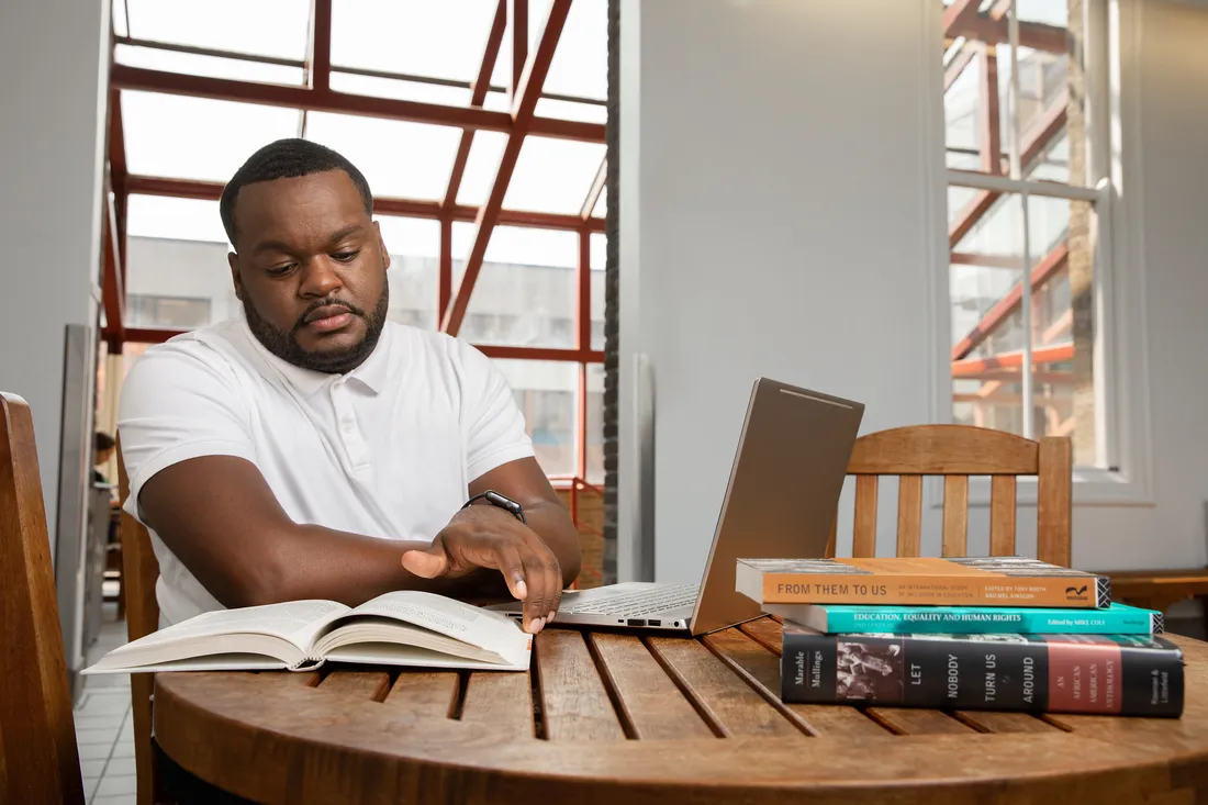 Terrance King reading and working on computer.