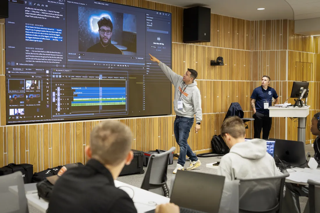 Professor Milton Santiago standing in front of a classroom and pointing at a projector screen.