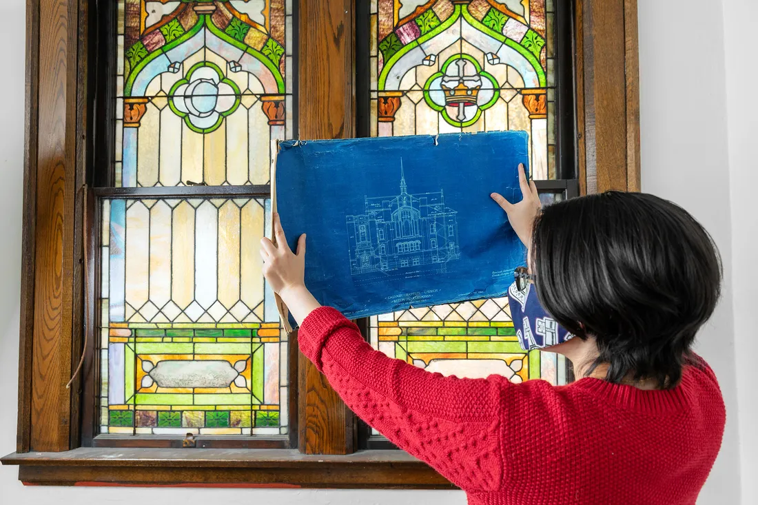 Professor looks at blue print of building.