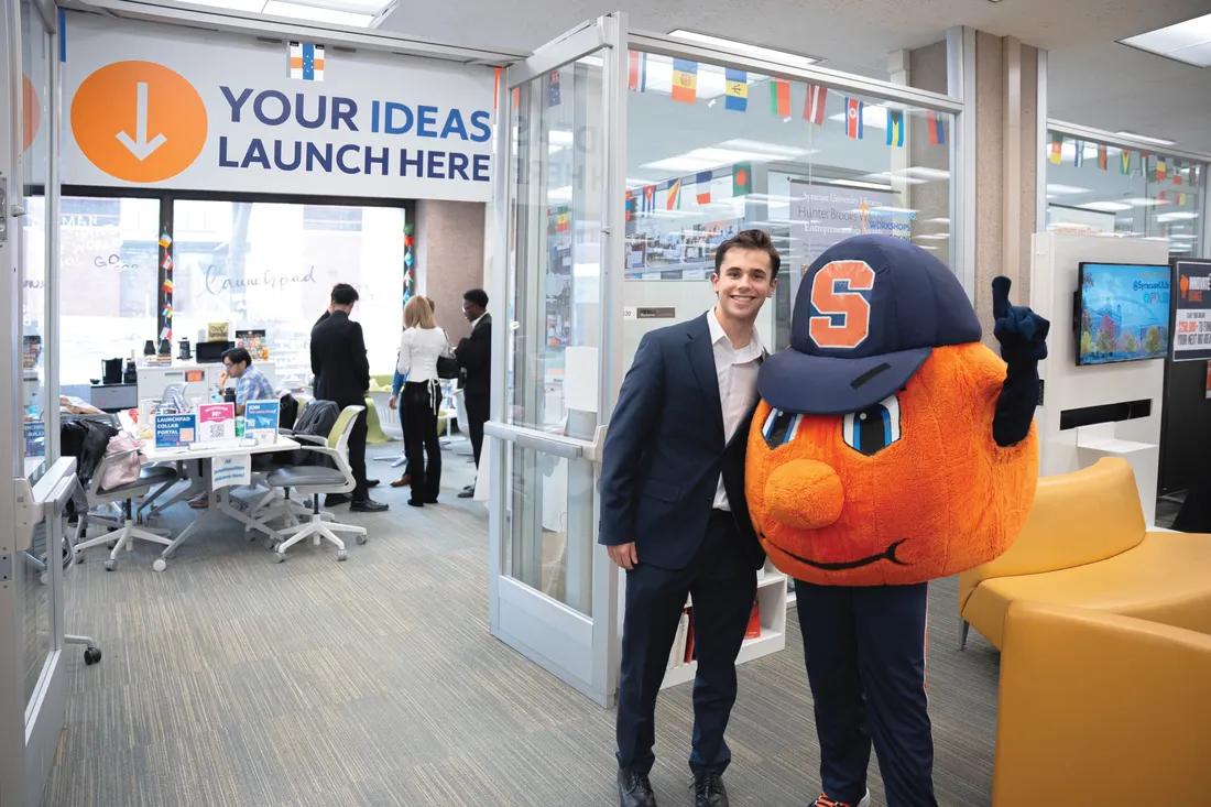 Jay Slaven '29 standing with Otto the Orange outside of the Syracuse University Libraries' Launchpad.