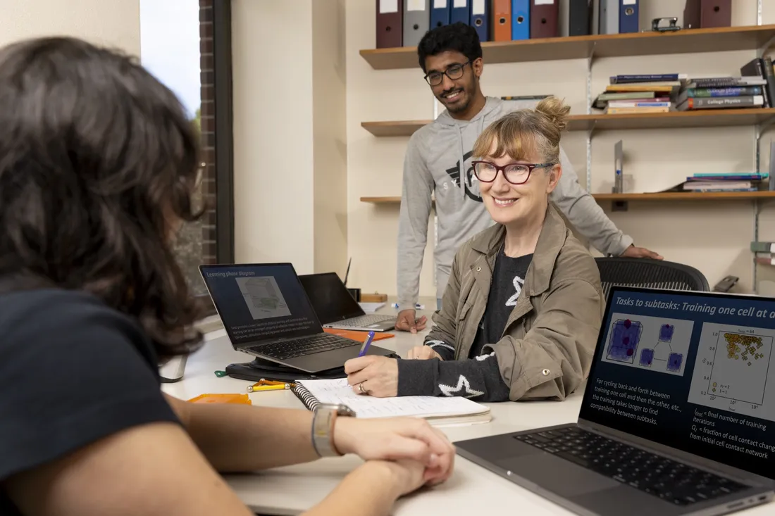 Professor at Syracuse University working with students in her office.