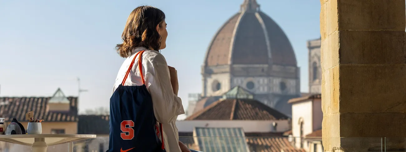 A student with a syracuse university backpack on in front of the Duomo in Florence Italy.
