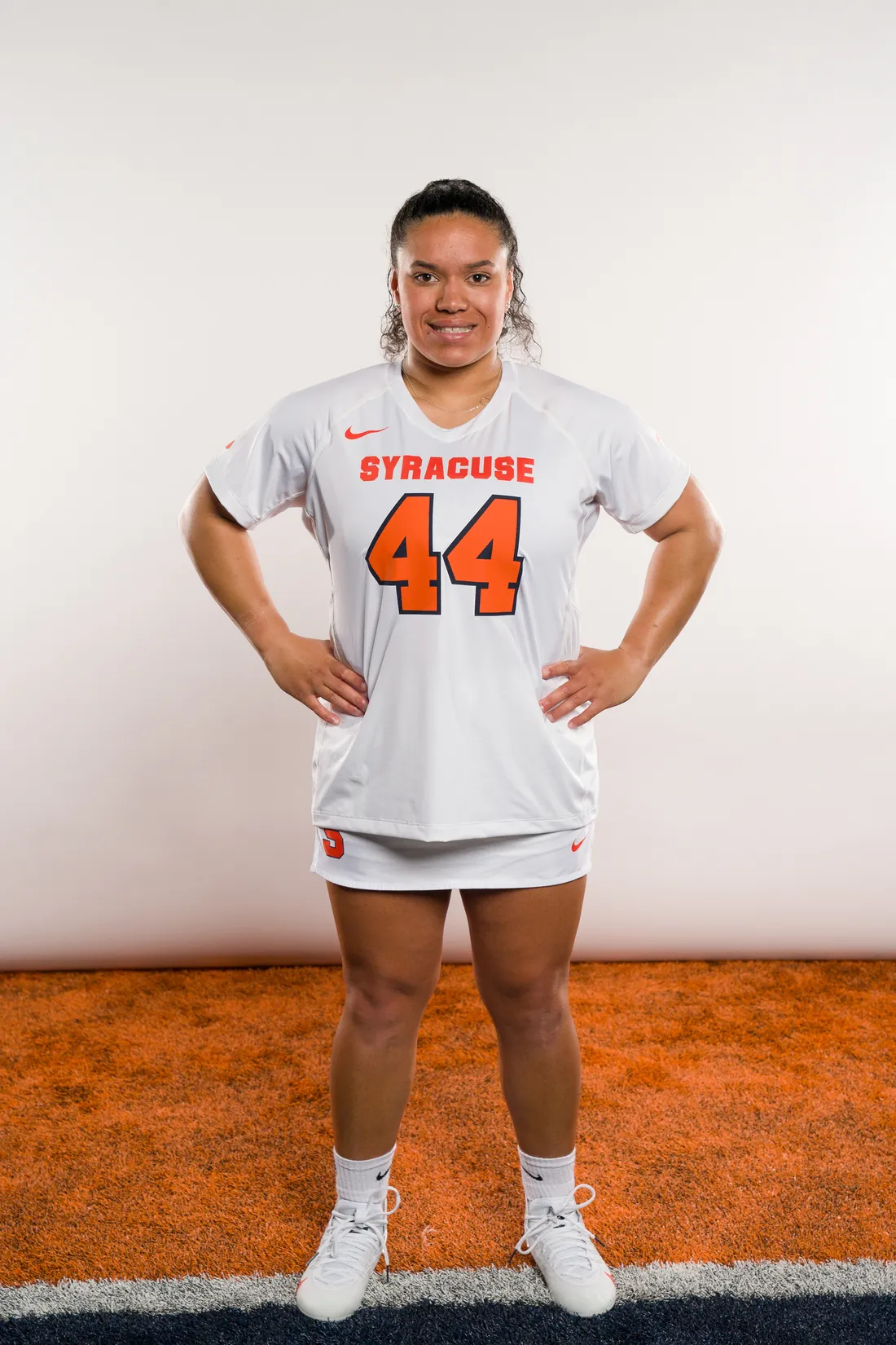 Person standing with hands on hips in sports uniform.