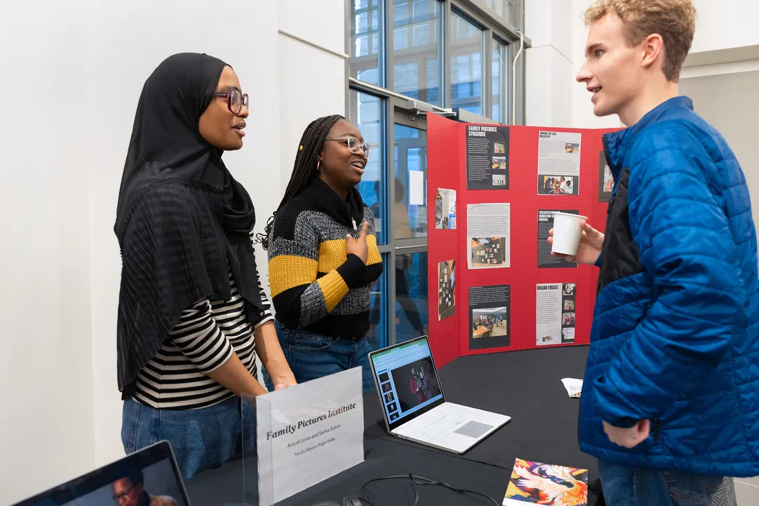 People presenting to person at a booth.