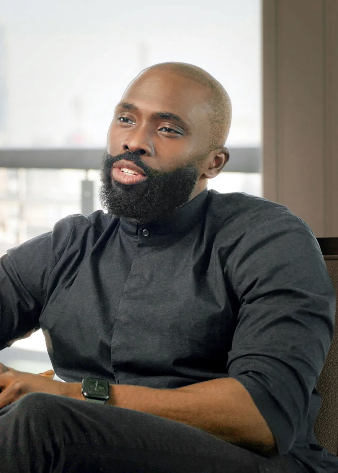 Oluwaleke Leke Osinubi's sitting on a chair and talking.