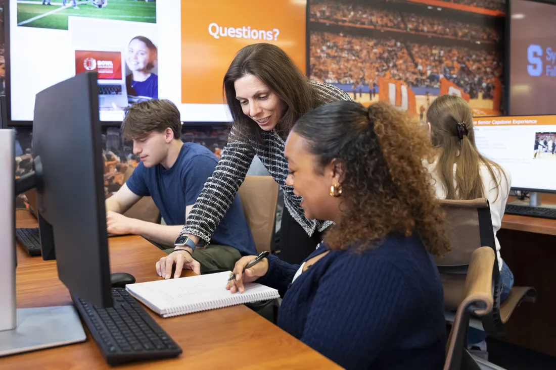 Professor in the David B. Falk College of Sport speaking with a student.