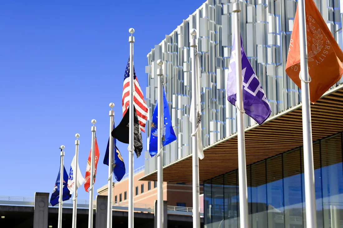 Flags outside the Daniel and Gayle D’Aniello Building on Syracuse University's campus.