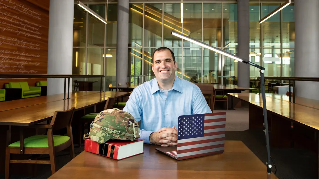 Portrait of Ryan Marquette sitting and smiling.