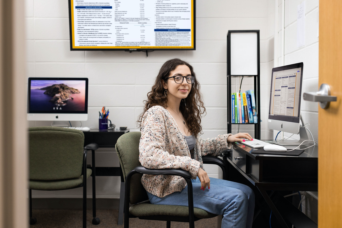 Veronica Bucci sits at a desk.