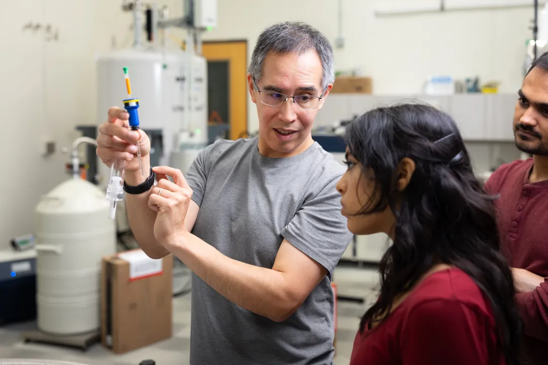 Carlos Castañeda showing his students a laboratory syringe.