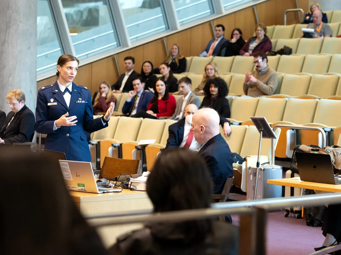Air Force Major standing in Syracuse University's Dineen Hall speaking at a military court hearing.