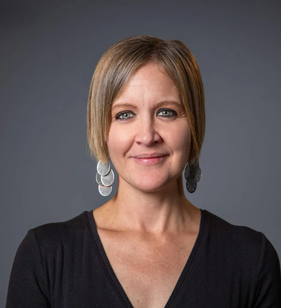 Liz Green in a black v-neck t-shirt.