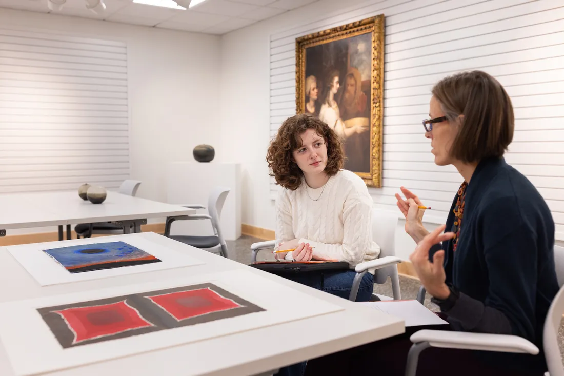 Sascha Scott speaking with a person at a museum review.