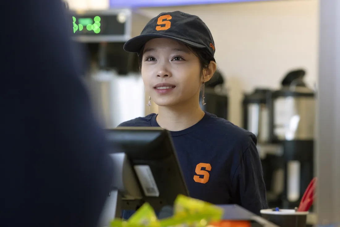 Student worker Abby Zhang '29 speaking with a customer.