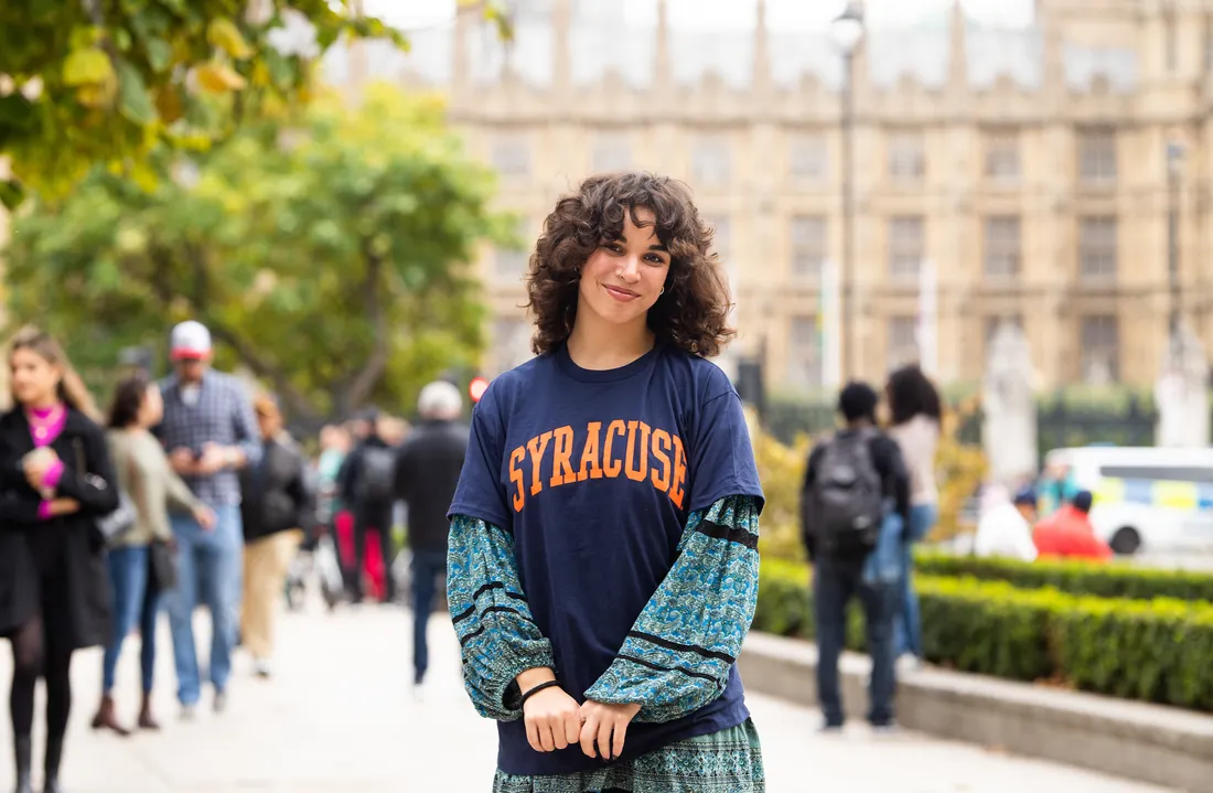 Student in London standing and smiling.