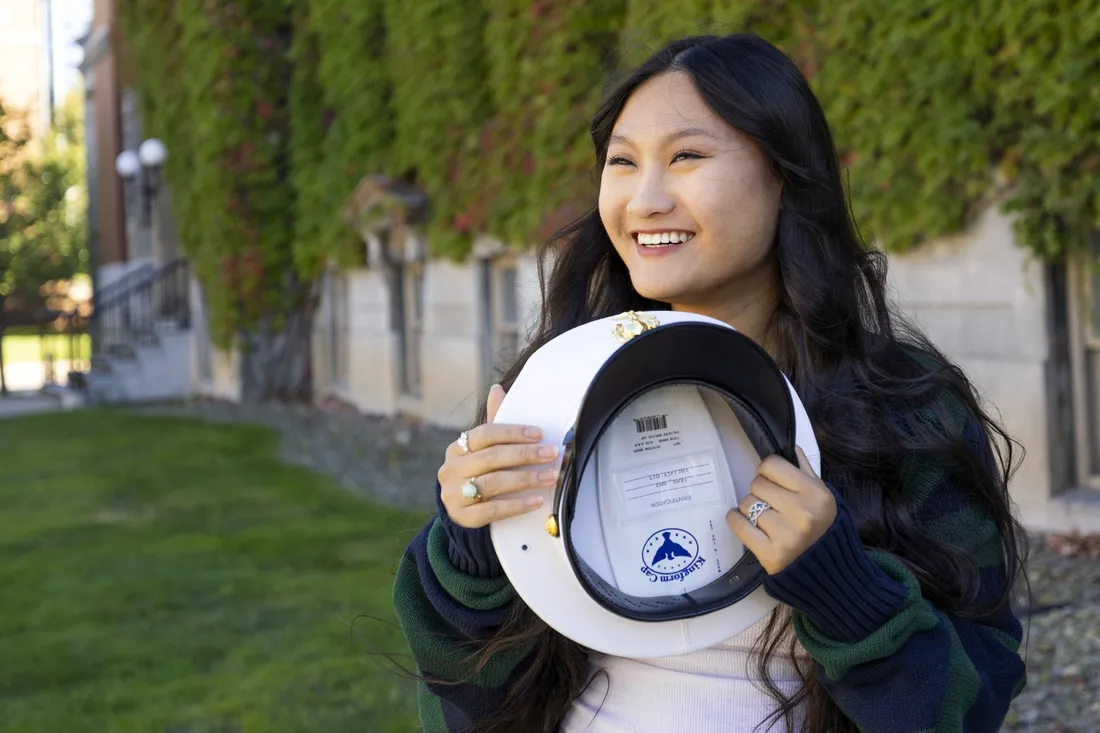 Amy Tran ’27 holding her military hat and smiling.