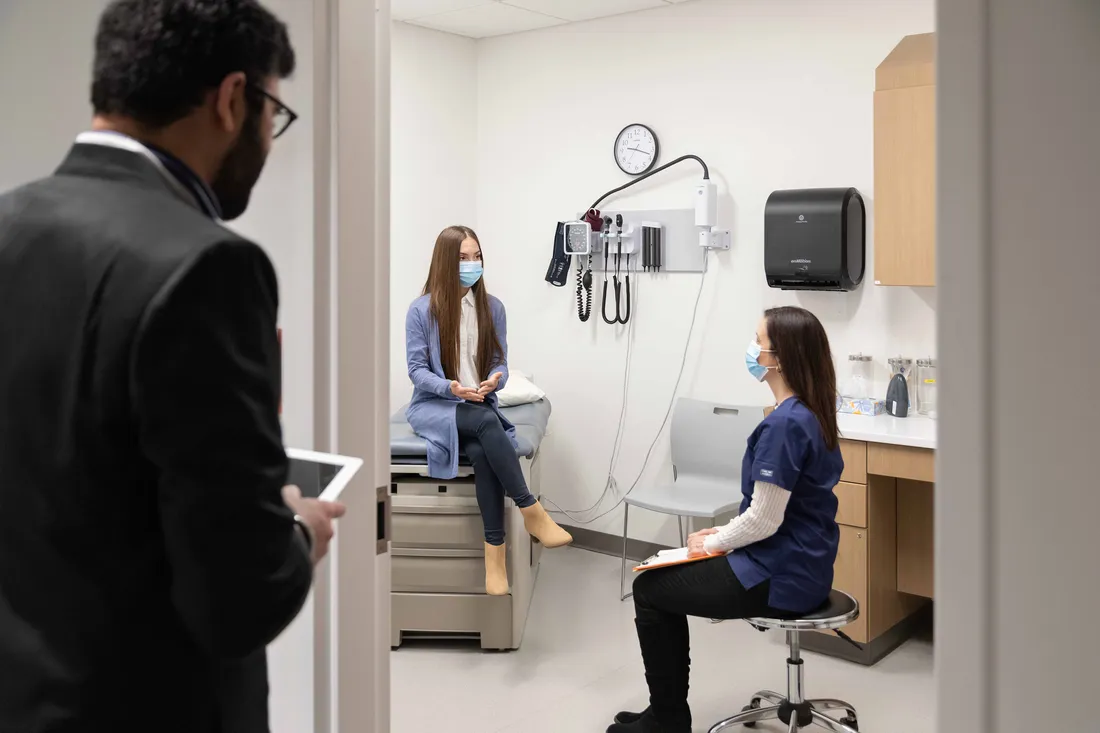 Healthcare administration group sitting in exam room.