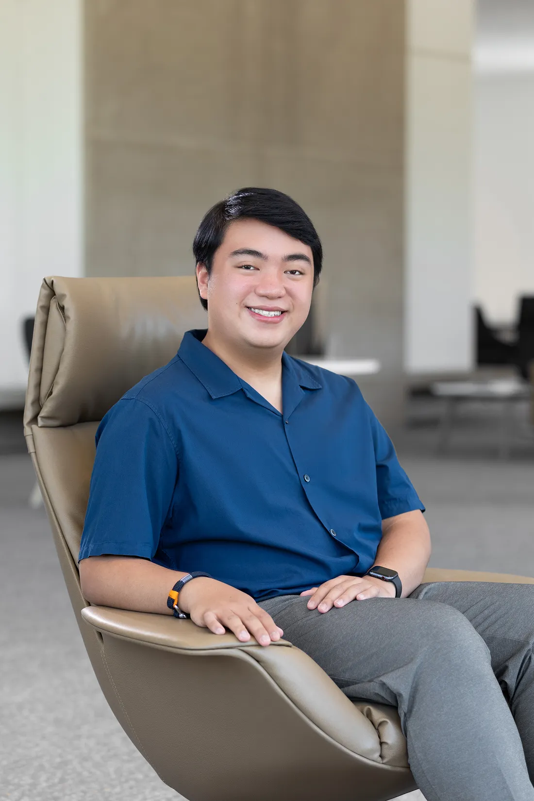 Enrique Prejula sits in chair smiling for camera