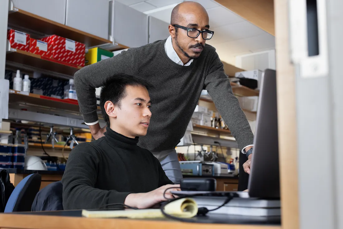 Braimah and student stand in front of computer.