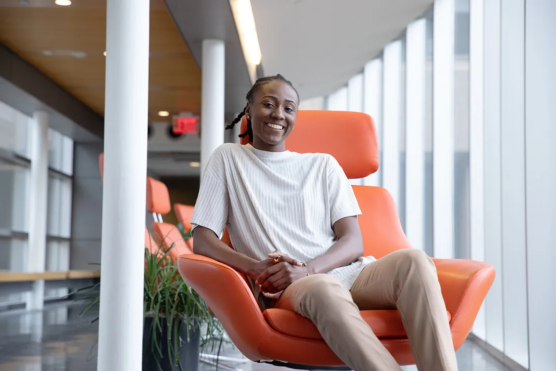 Kelsey Davis sits in orange chair.