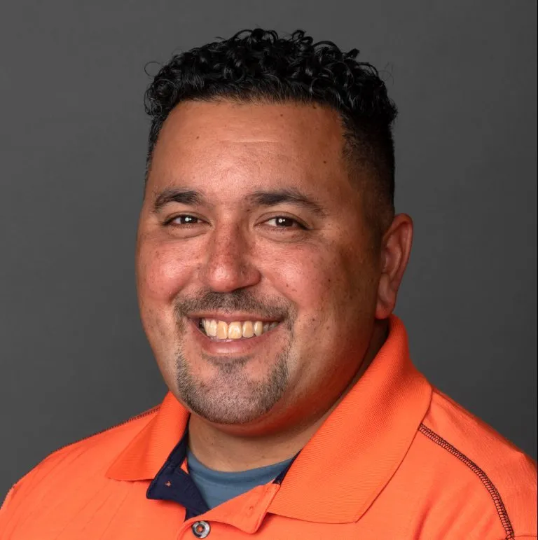 Julio Rodriguez smiling in a orange polo.