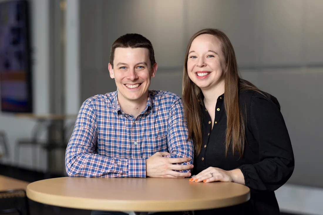 Alumni Alex Brewer and Molly Nelson sitting and smiling.