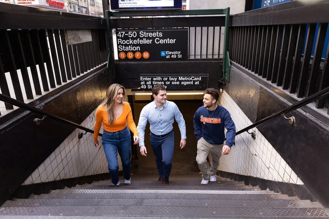 People walking up stairs at New York City subway station.