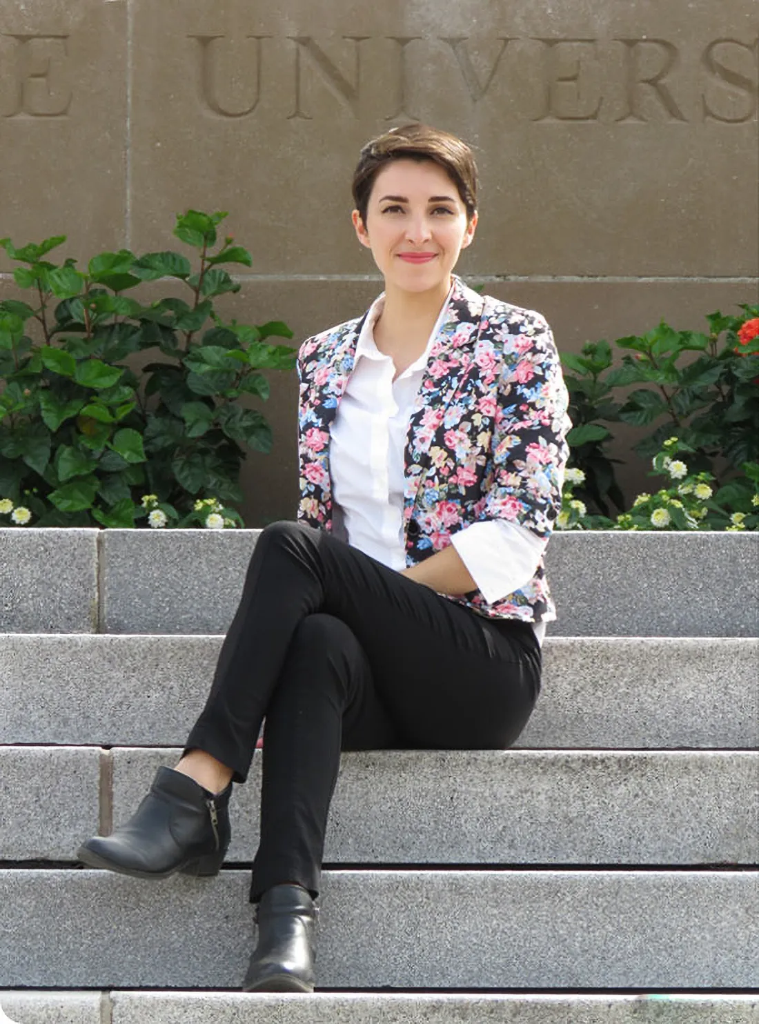 Syracuse alumna Lauren Romero poses for a photo in front of the hall of languages.