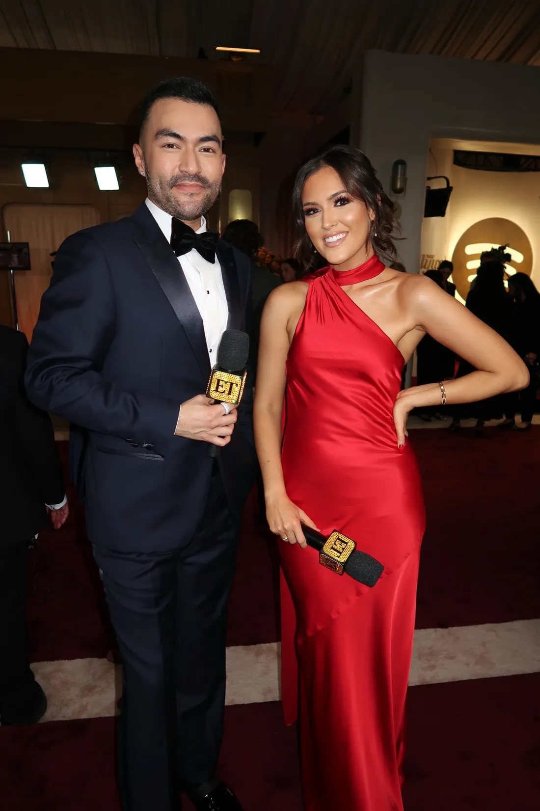 Cassie DiLaura '15 standing with her Entertainment Tonight co-host on a red carpet event.