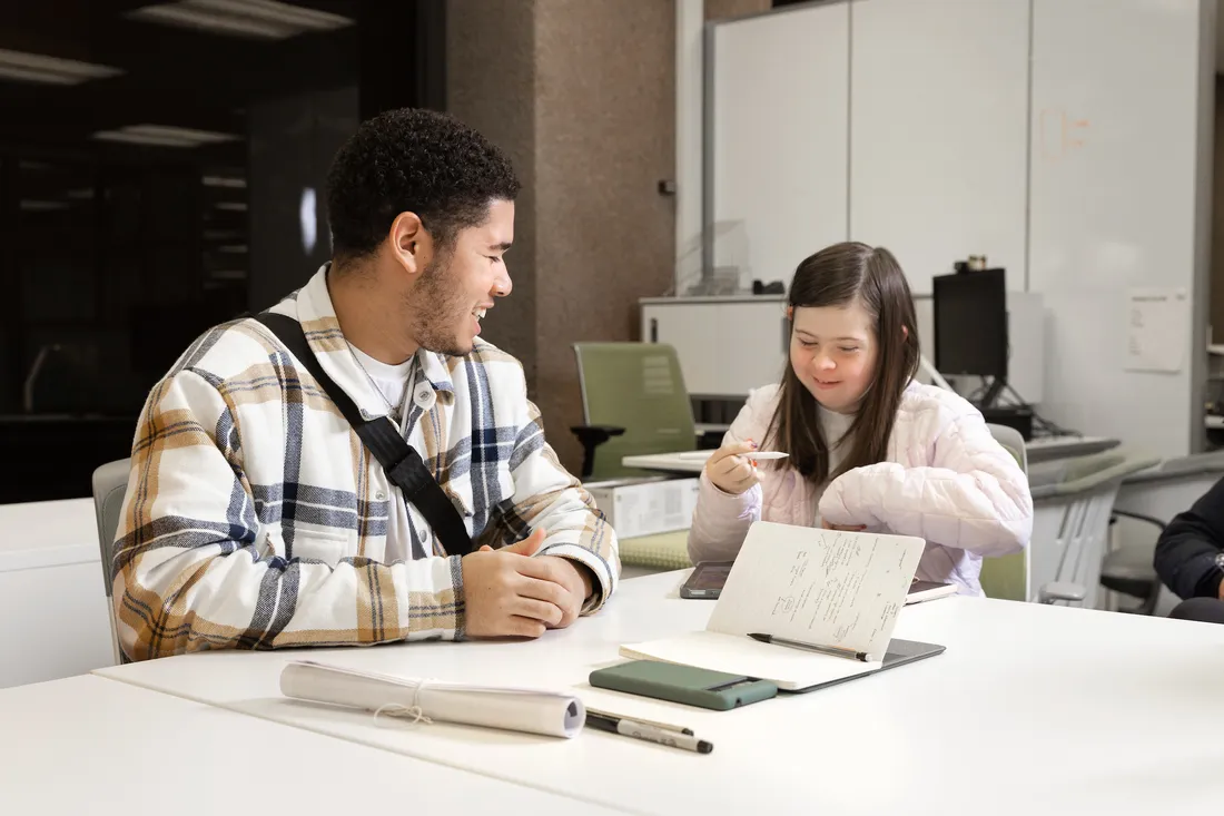 Two students sitting in chairs.