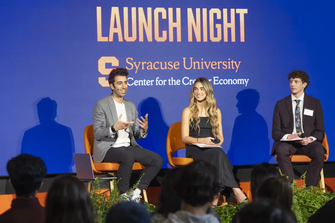 Students sitting on stage and talking at the Center for the Creator Economy launch night.