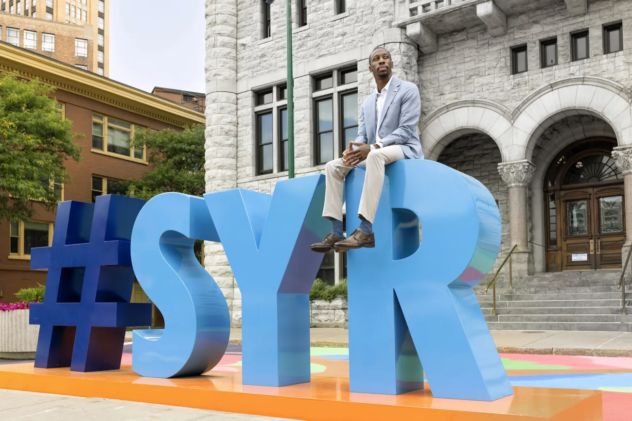 George Lynch ’26 sitting on top of the #SYR statue in downtown Syracuse.