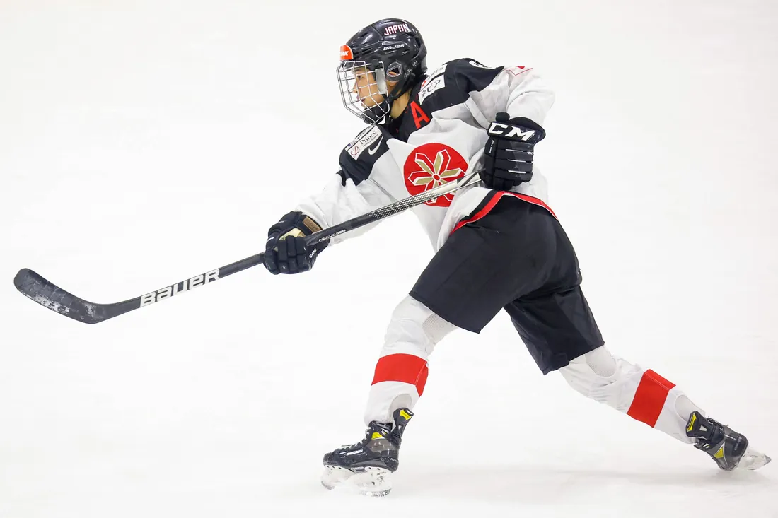 Akane Hosoyamada in hockey uniform takes slapshot.