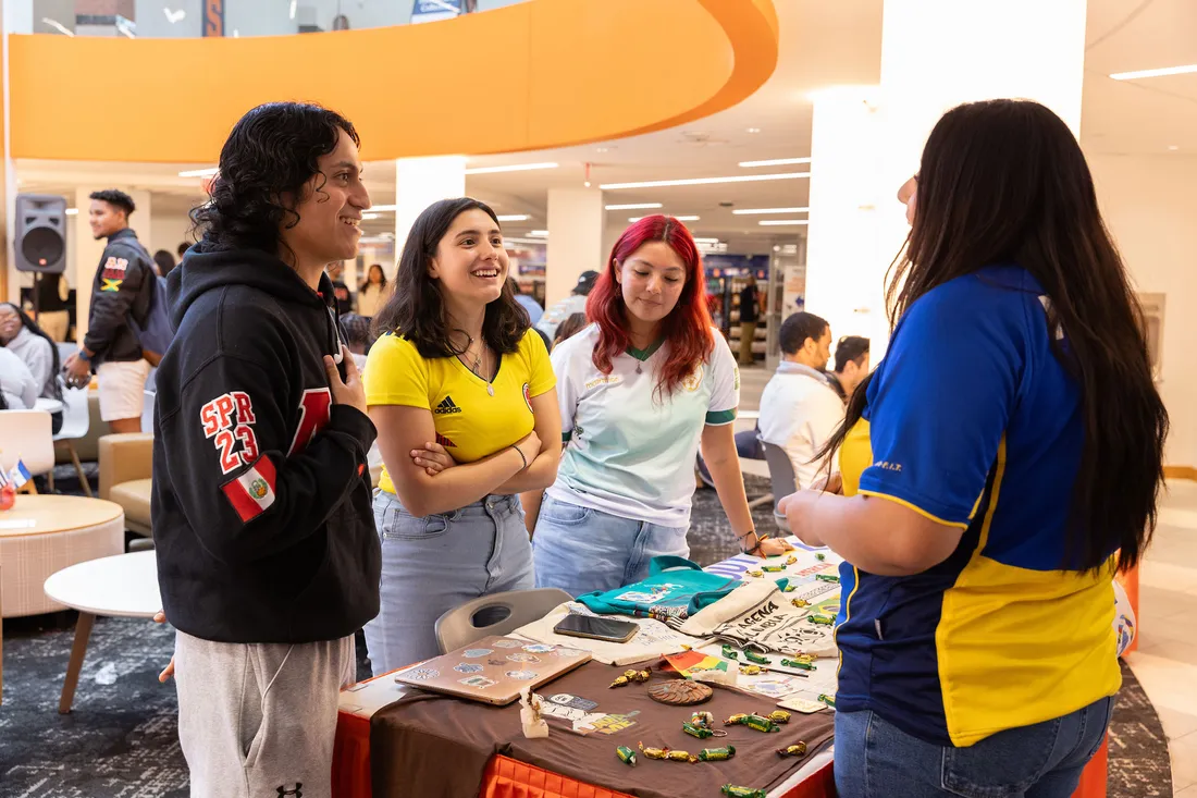 Students chat around table in the Schine Student Center.
