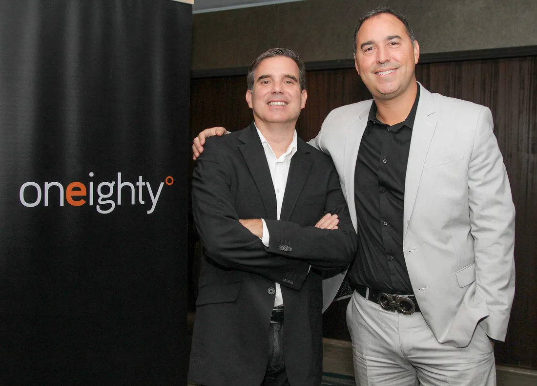 People posting for picture next to a sign.