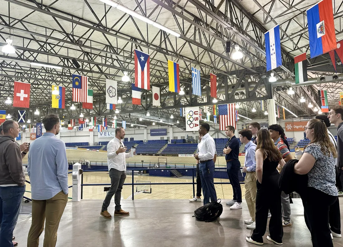 Students standing inside of the VELO Sports Center in Los Angeles attending a tour led by Olympian Adam Duvendeck.