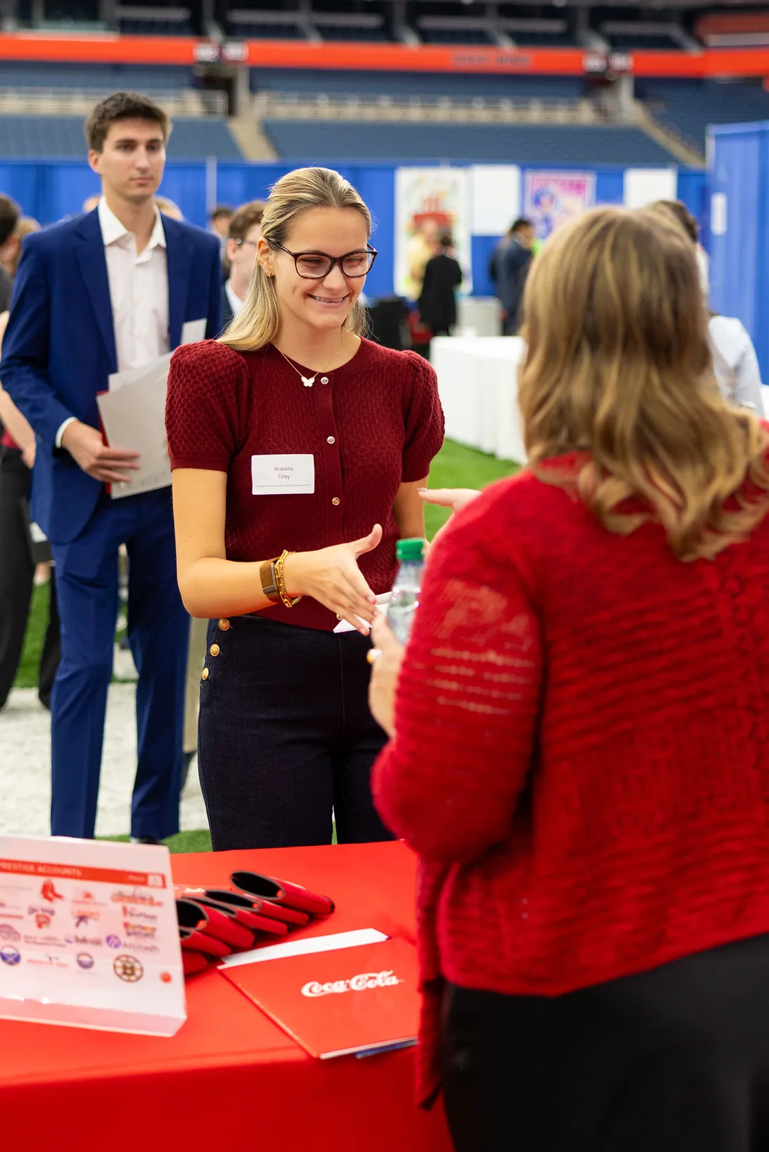 People talking at a booth at a career fair.