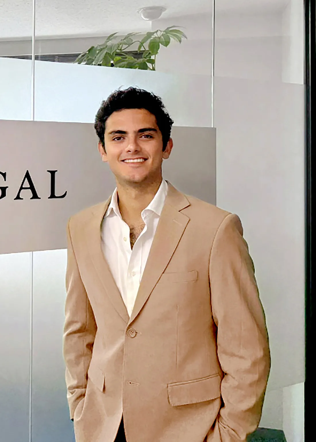 Student standing infront of a sign at their summer internship.
