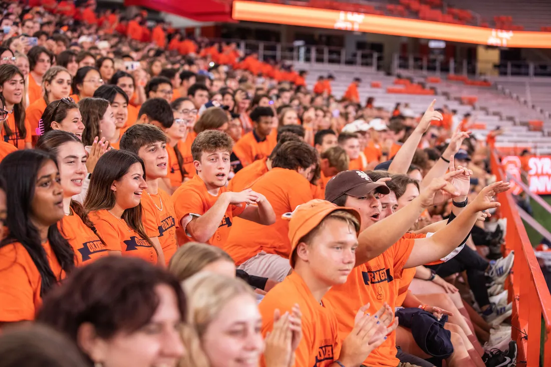 Students cheering together in the JMA Wireless Dome wearing orange.