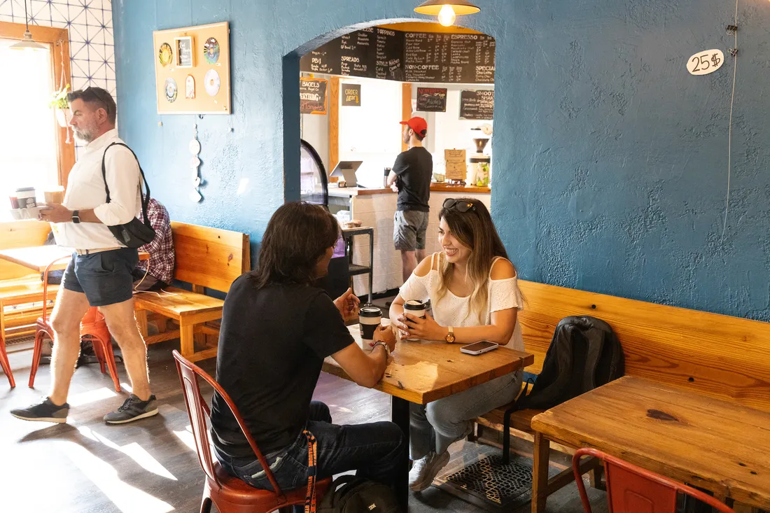Two students are sitting at a table and talking.