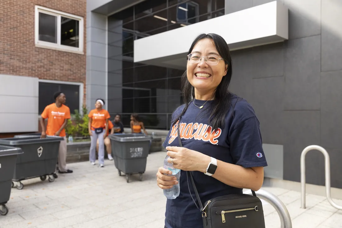 Xihui Newman standing outside of Shaw Hall smiling.