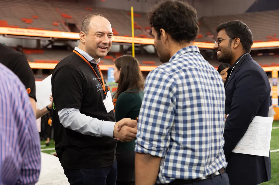 Endri Mataj shaking a students hand.