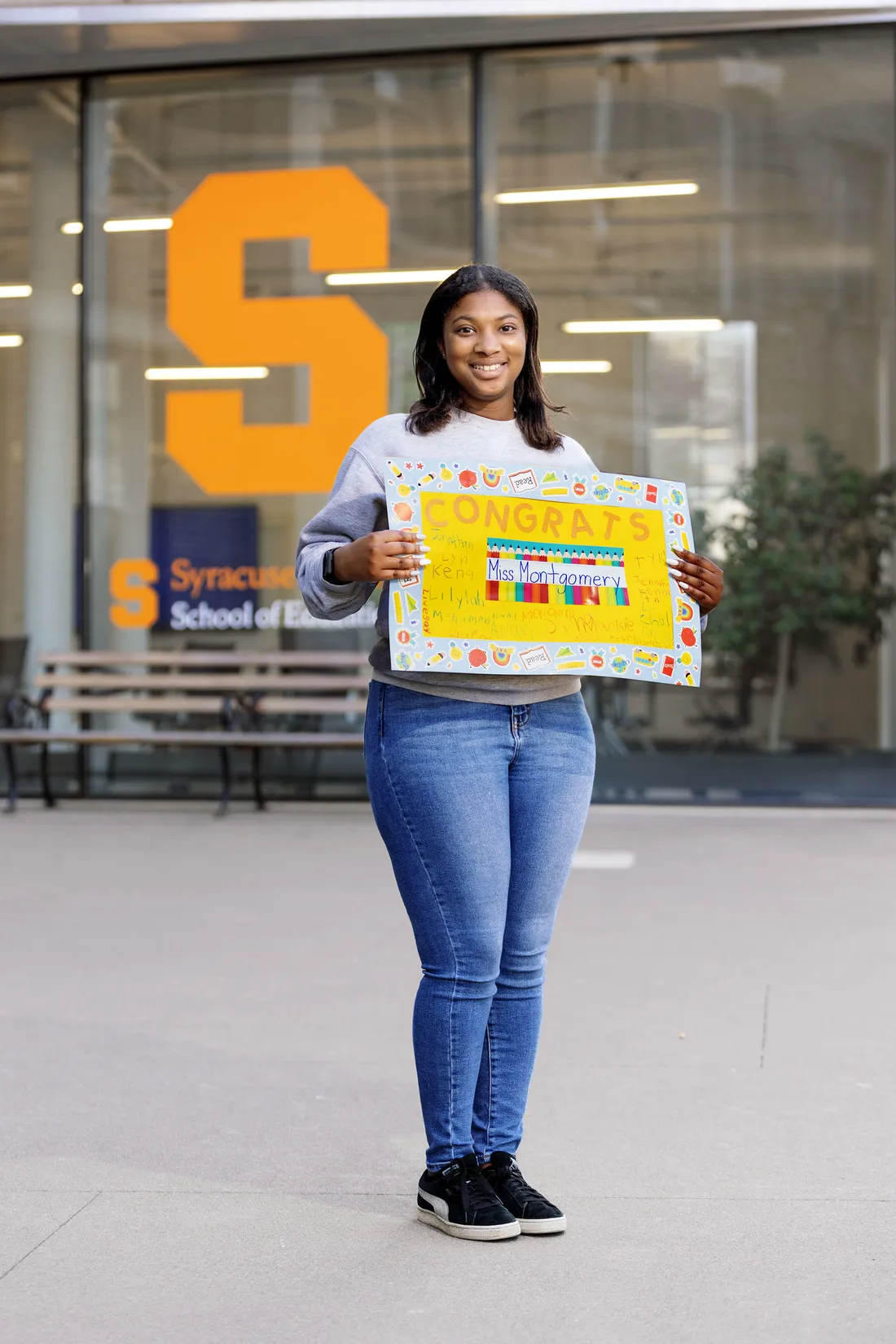 Kamille Montgomery smiling and holding a sign.