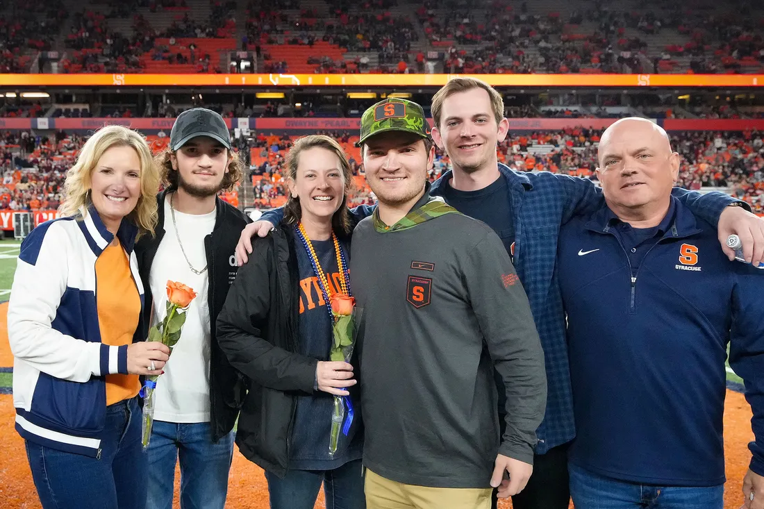 Mom, dad, and four adult children pose together for a photo in the JMA Wireless Dome.