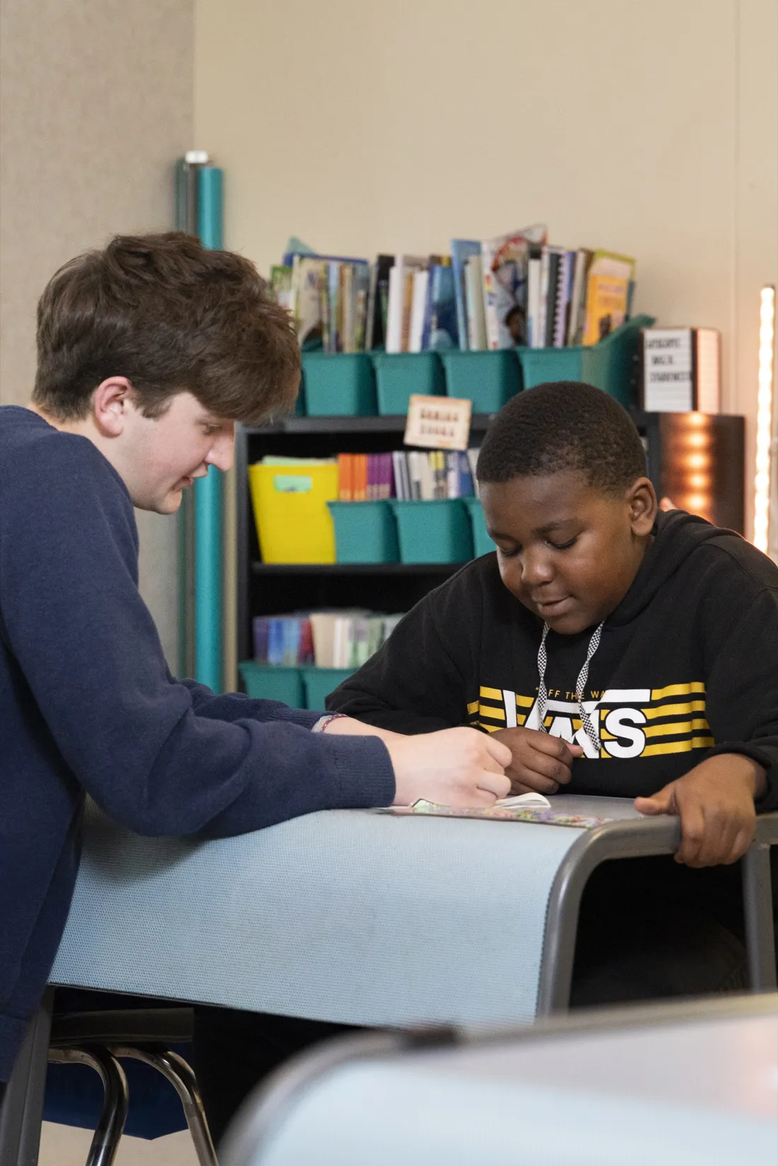 Will Baker working with a student at a table.
