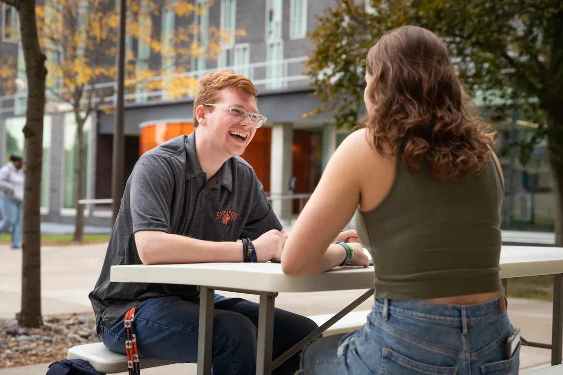 Students sitting on a bench outside.