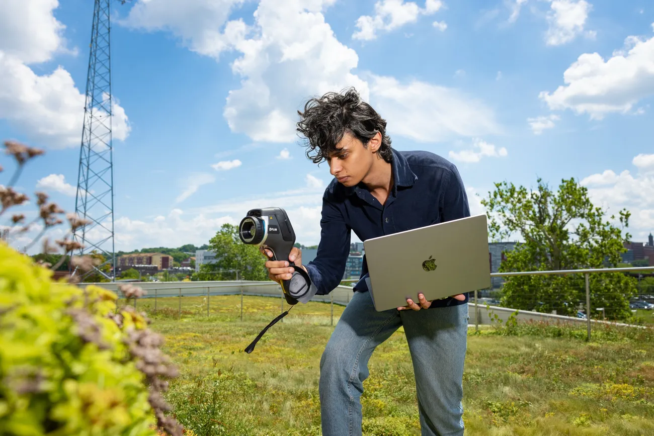 Emanuel Boutros '27 holding a scanning device to measure airflow on the roof of the Center of Excellence.