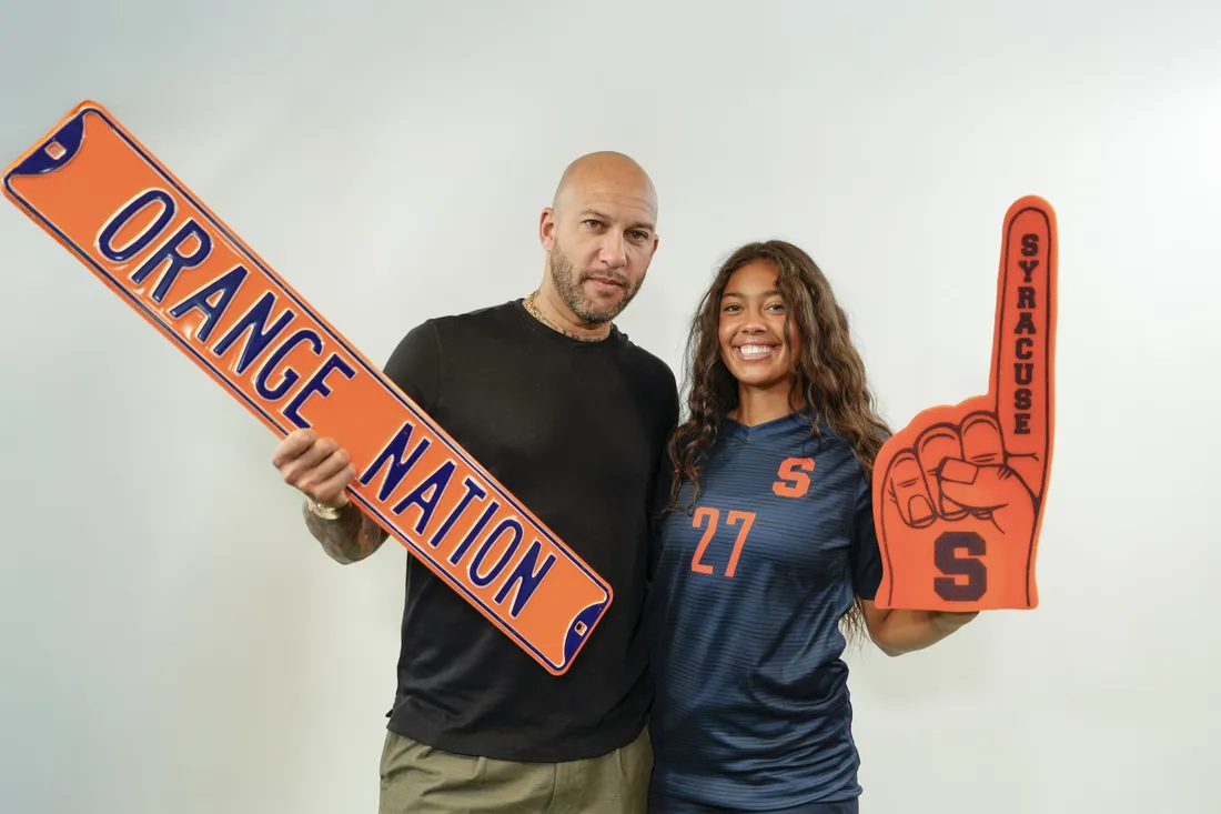 Soccer athlete Ali Howard standing with her father, Tim Howard, a famous goalkeeper.