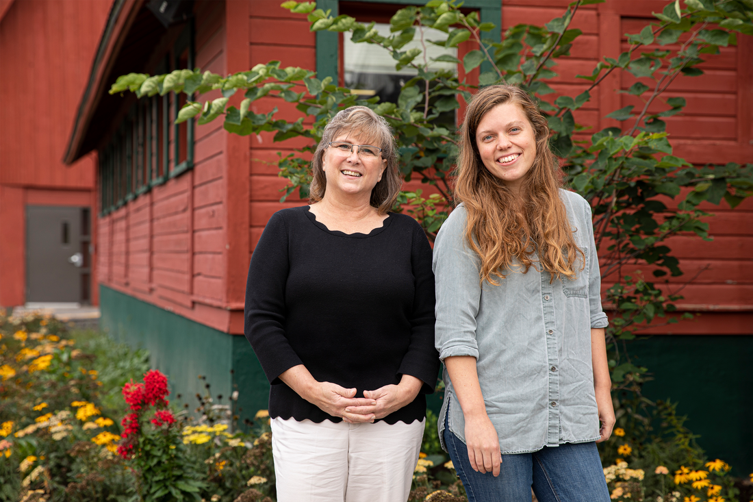 Melissa Cadwell and Meg Lowe posed outside a building, smiling.