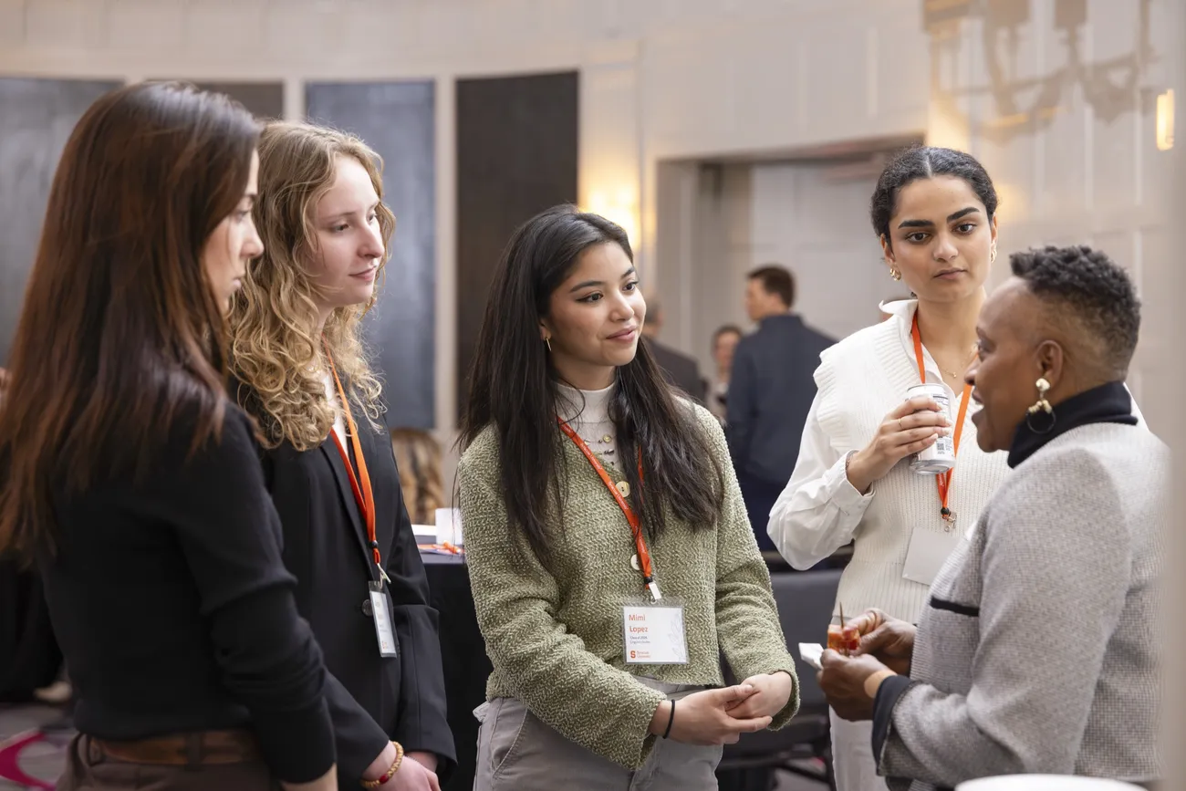 A group of Syracuse University students and alumni speaking at a Boston Immersion event.
